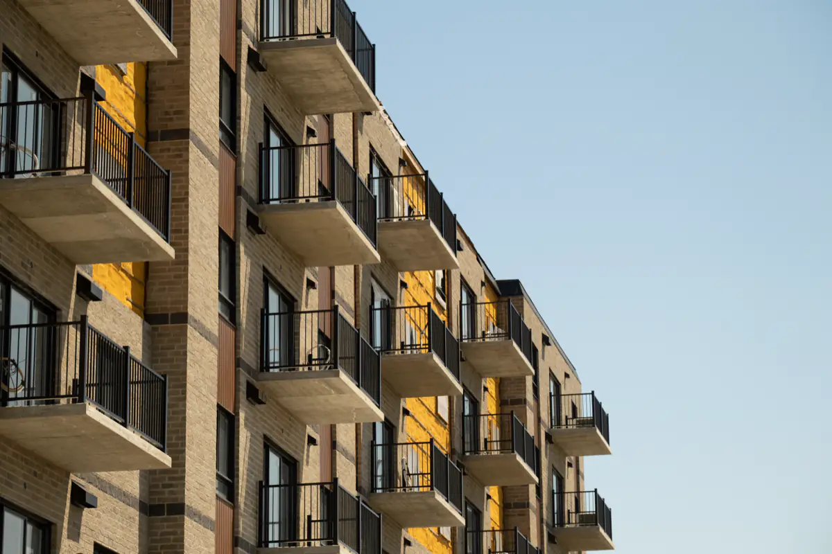 Balcons d’un immeuble en brique, garde-corps noirs à barreaux