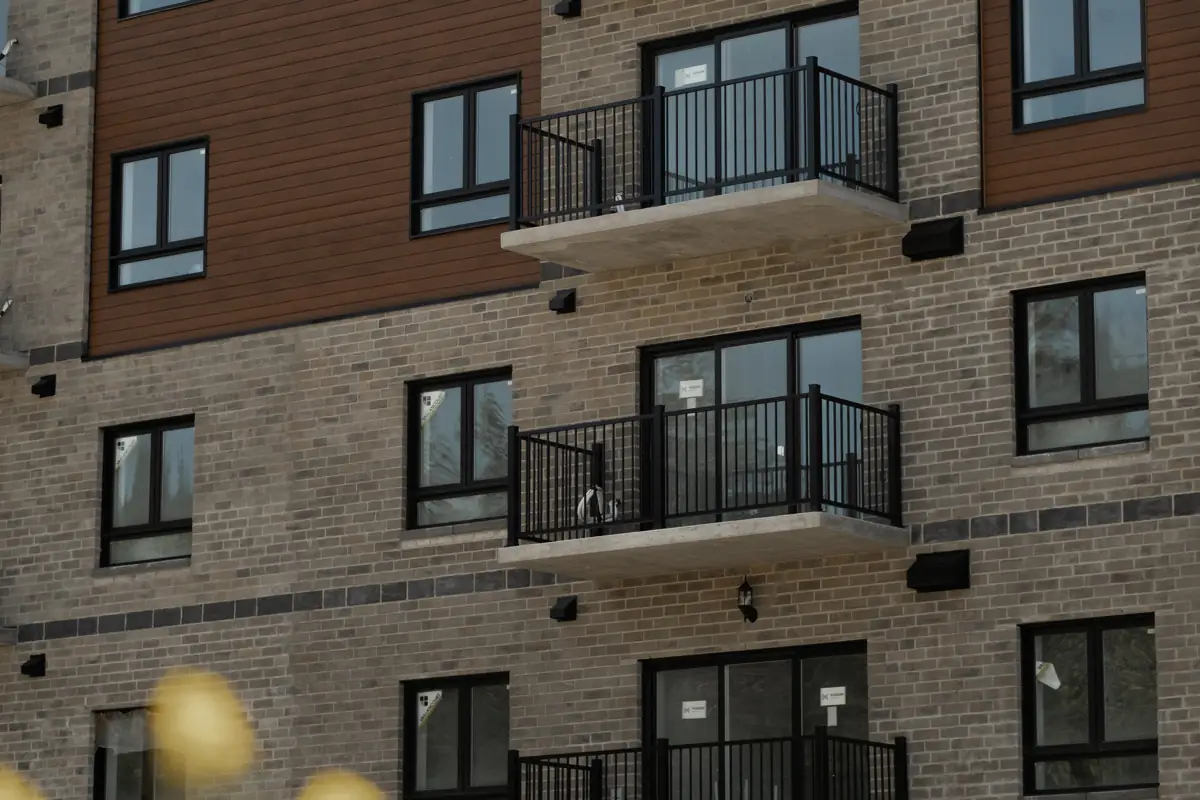 Immeuble de brique et de bois, balcons à barreaux noirs