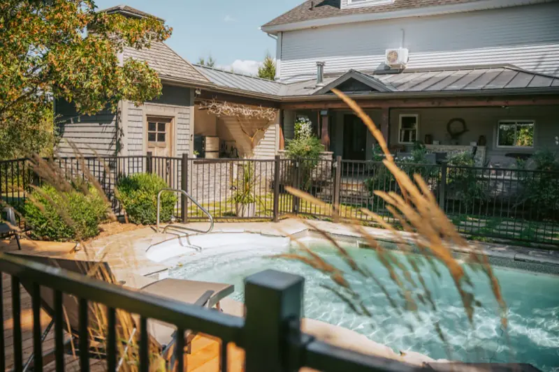 Piscine creusée entourée d’une clôture noire à barreaux