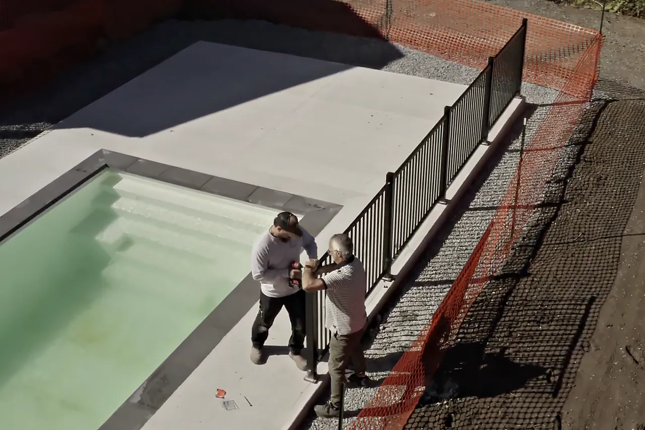 Deux installateurs posent une clôture de piscine Williams